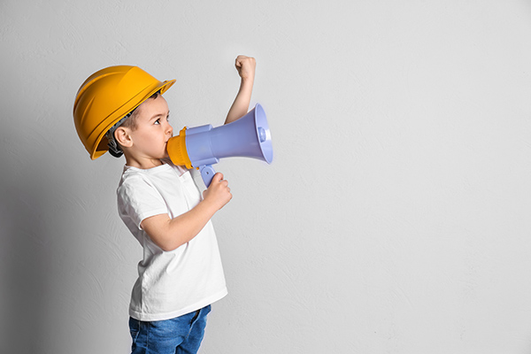 Kleiner Junge ruft per Megafon zu Kinderrechten auf